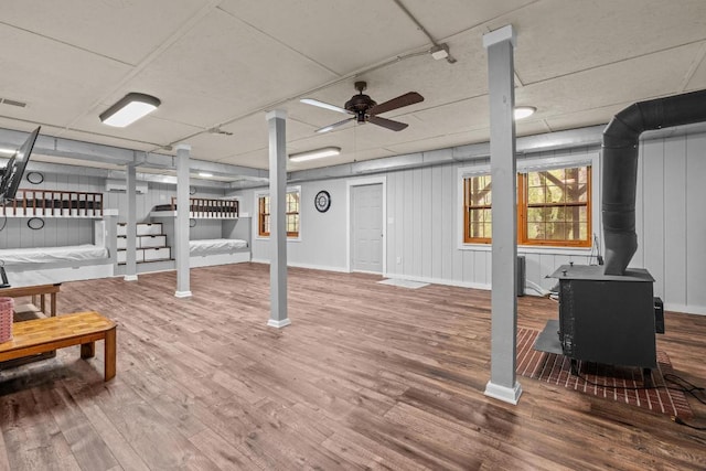 130 Sarah Cove Rd, Otto, NC 28763 - below grade area with a wood stove, wood finished floors, and baseboards