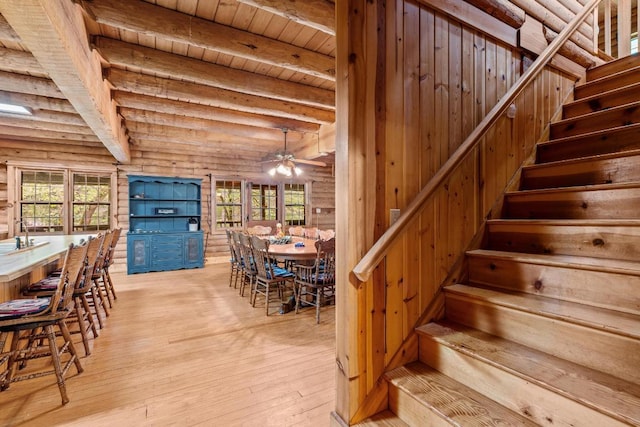 130 Sarah Cove Rd, Otto, NC 28763 - dining area with stairway, light wood-style floors, a ceiling fan, wood ceiling with exposed beams, and rustic walls