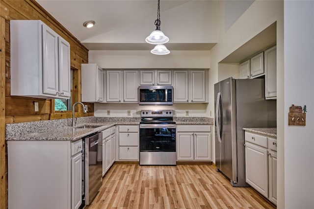 142 Golden Mist Ct, Sapphire, NC 28774 - kitchen with appliances with stainless steel finishes, a sink, light stone counters, light wood-style flooring, and decorative light fixtures