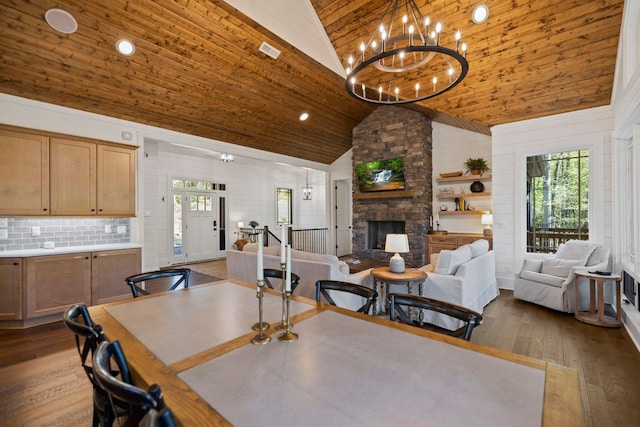 dining space featuring a healthy amount of sunlight, wood ceiling, a fireplace, and high vaulted ceiling
