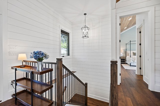 interior space with baseboards, wood walls, and wood finished floors