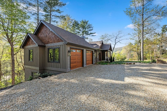 view of side of property featuring an attached garage and driveway