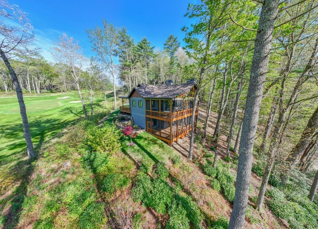 back of house with a lawn, a chimney, a shingled roof, and a deck