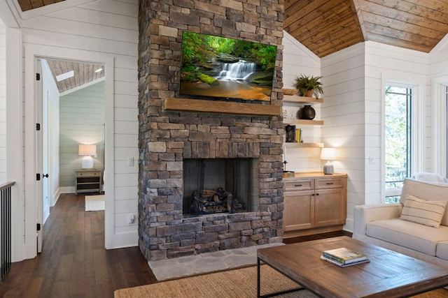 living room with dark wood-style flooring, a stone fireplace, vaulted ceiling, wood walls, and wooden ceiling