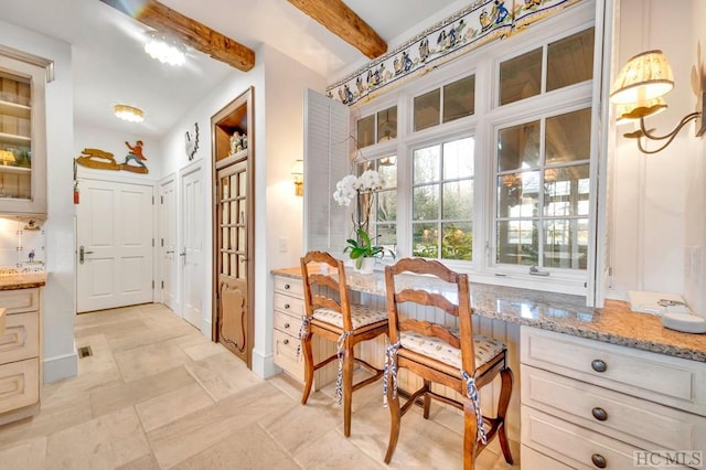 dining area featuring beam ceiling