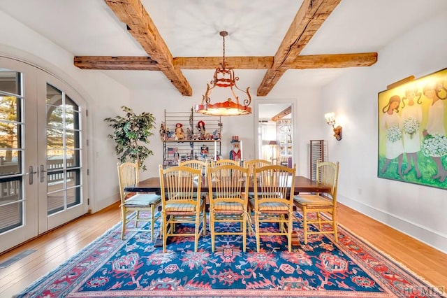 dining space with beamed ceiling, coffered ceiling, hardwood / wood-style floors, and french doors