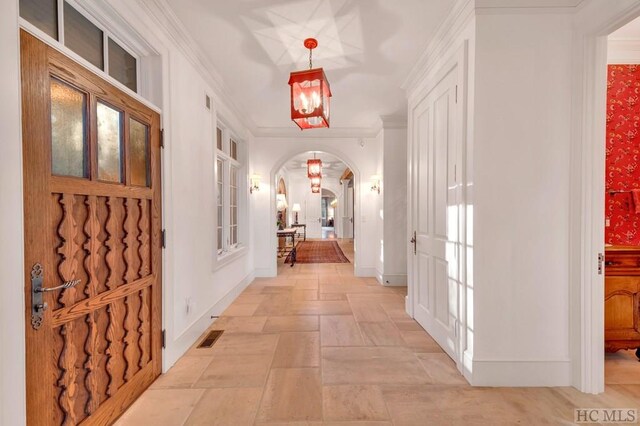 hall with crown molding and a notable chandelier