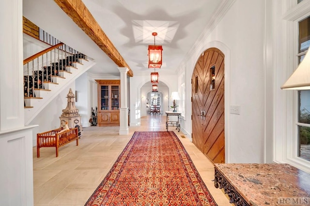 entryway featuring ornate columns and crown molding