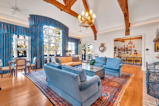 living room featuring ceiling fan with notable chandelier, beam ceiling, and light hardwood / wood-style floors