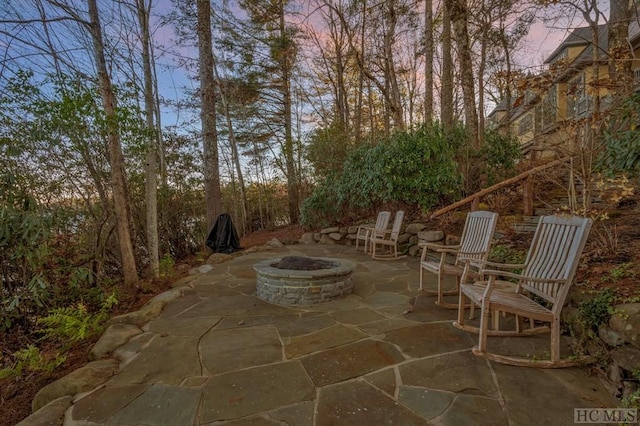 patio terrace at dusk featuring a fire pit