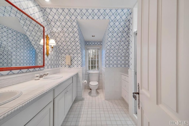 bathroom with tile patterned floors, toilet, vanity, and tile walls