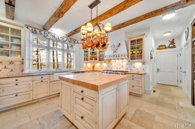 kitchen featuring wood counters, hanging light fixtures, a kitchen island, and backsplash