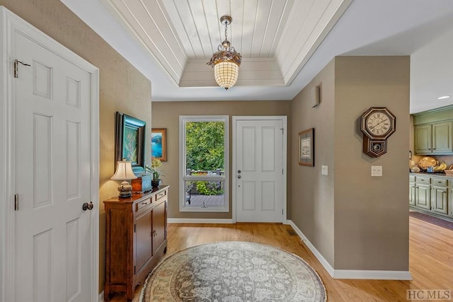 entrance foyer with a raised ceiling and light hardwood / wood-style floors