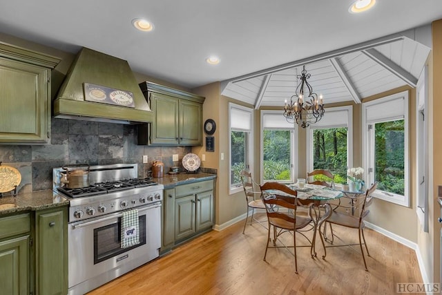 kitchen featuring lofted ceiling, high end stainless steel range, custom exhaust hood, tasteful backsplash, and green cabinetry