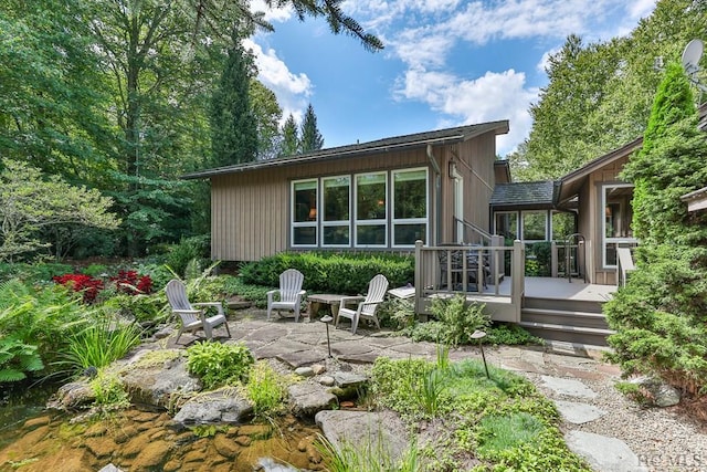 rear view of property featuring a patio and a deck