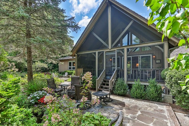 rear view of property with a patio area and a sunroom