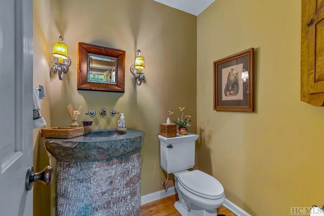 bathroom with wood-type flooring and toilet