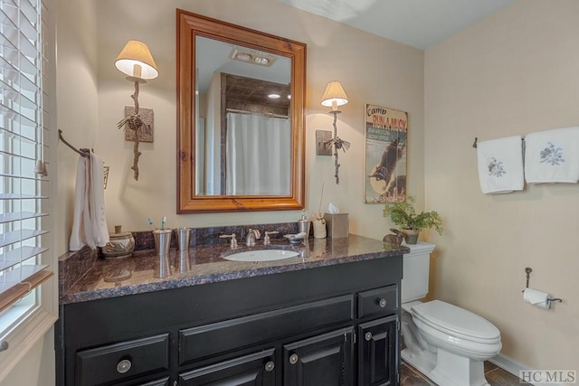 bathroom with vanity, a healthy amount of sunlight, toilet, and a shower with shower curtain