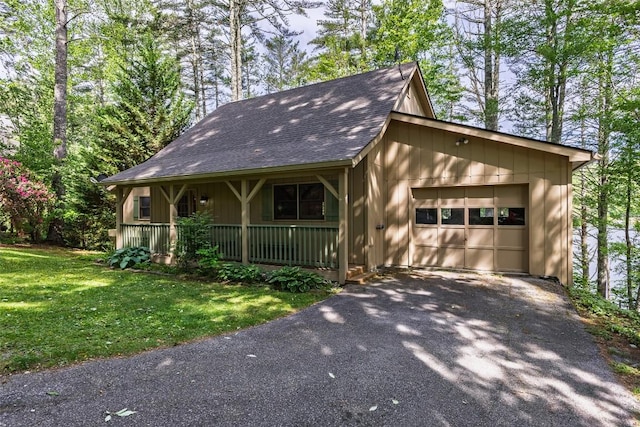 1964 Woods Mountain Trl, Cullowhee, NC 28723 - view of front facade with covered porch, driveway, a shingled roof, a front yard, and a garage