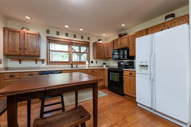 1964 Woods Mountain Trl, Cullowhee, NC 28723 - kitchen featuring black appliances, a sink, recessed lighting, light wood-style flooring, and light countertops
