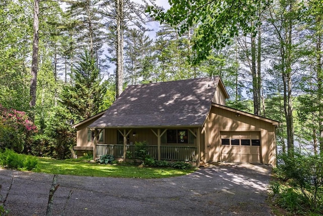 1964 Woods Mountain Trl, Cullowhee, NC 28723 - view of front of house featuring a garage, asphalt driveway, a porch, and a shingled roof