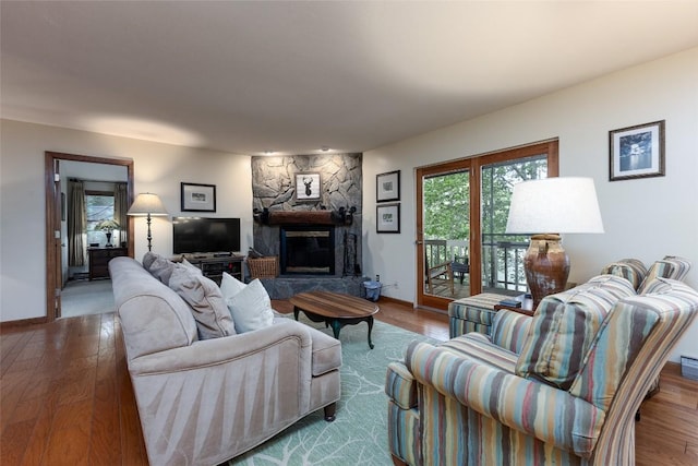 1964 Woods Mountain Trl, Cullowhee, NC 28723 - living room featuring a stone fireplace, wood finished floors, and baseboards