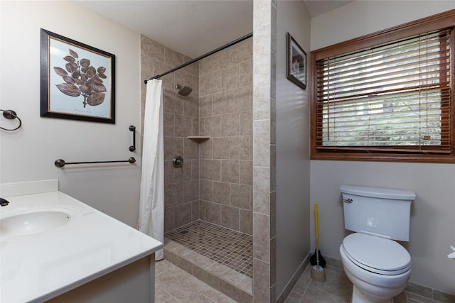 1964 Woods Mountain Trl, Cullowhee, NC 28723 - bathroom featuring vanity, a tile shower, tile patterned flooring, toilet, and baseboards