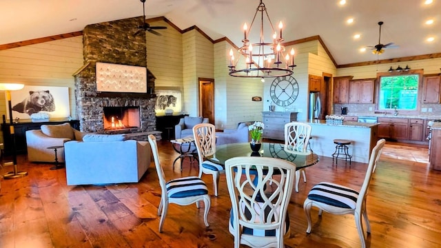 71 Raptor Way, Sapphire, NC 28774 - dining space featuring ceiling fan, wood-type flooring, wood walls, a stone fireplace, and crown molding
