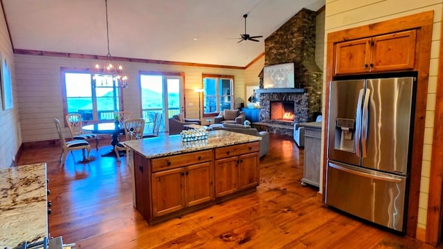 71 Raptor Way, Sapphire, NC 28774 - kitchen with stainless steel fridge with ice dispenser, wood walls, brown cabinetry, dark wood-type flooring, and a ceiling fan