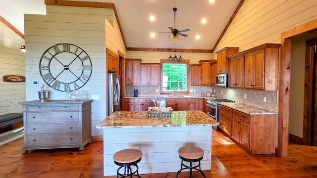 71 Raptor Way, Sapphire, NC 28774 - kitchen featuring appliances with stainless steel finishes, vaulted ceiling, a ceiling fan, brown cabinets, and tasteful backsplash