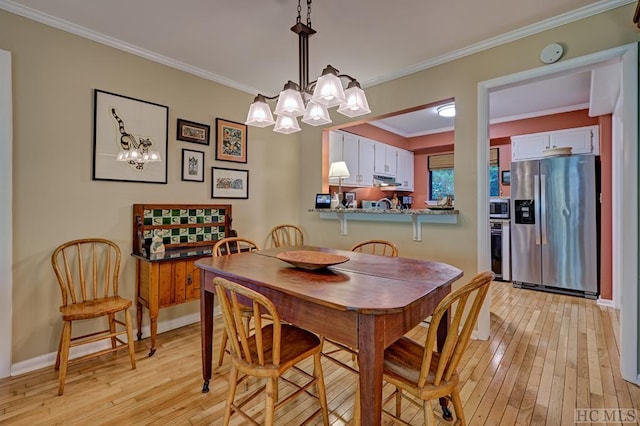 dining room featuring crown molding and light hardwood / wood-style flooring