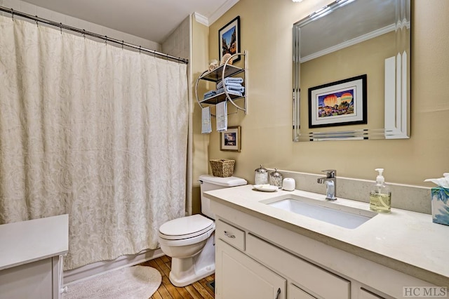 bathroom featuring toilet, vanity, hardwood / wood-style floors, and crown molding