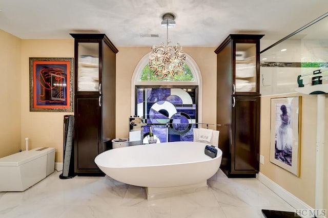 bathroom featuring a notable chandelier and independent shower and bath