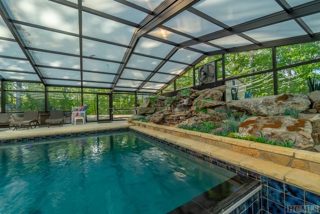 view of swimming pool featuring a patio area and a lanai