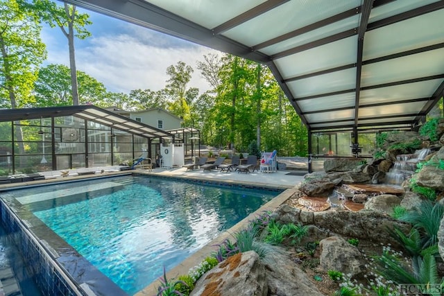 view of swimming pool featuring a lanai and a patio area