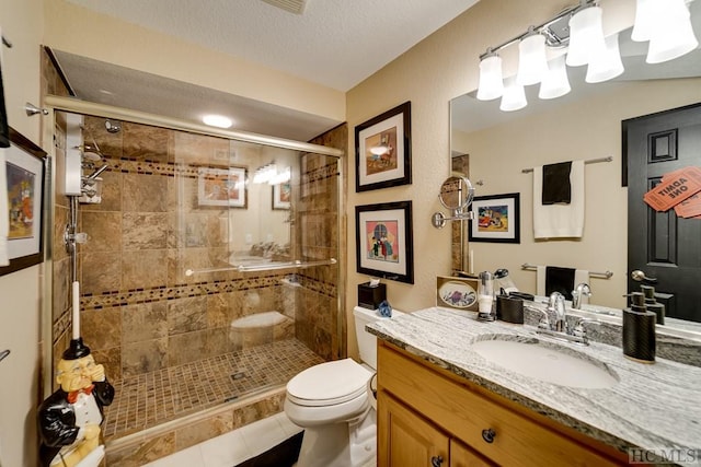 bathroom featuring vanity, walk in shower, a textured ceiling, toilet, and tile patterned floors