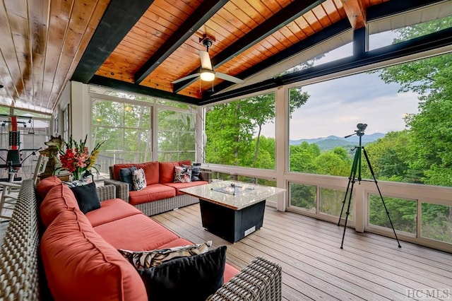 sunroom featuring ceiling fan, a mountain view, vaulted ceiling with beams, and wood ceiling