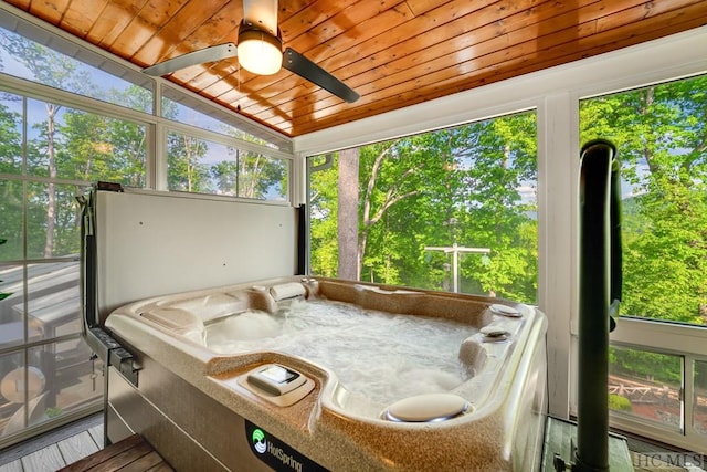 sunroom with lofted ceiling, plenty of natural light, a jacuzzi, and wooden ceiling