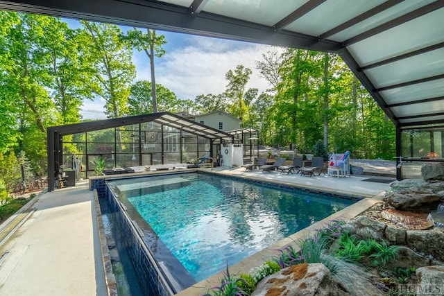 view of swimming pool featuring a lanai and a patio area