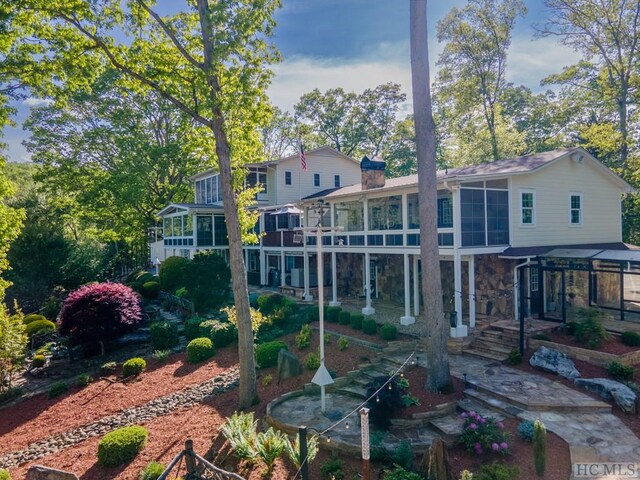 rear view of property featuring a sunroom