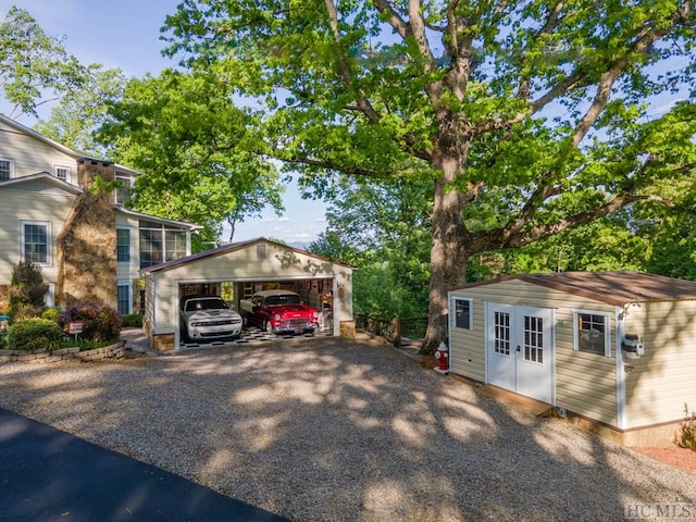 exterior space with a garage and an outbuilding