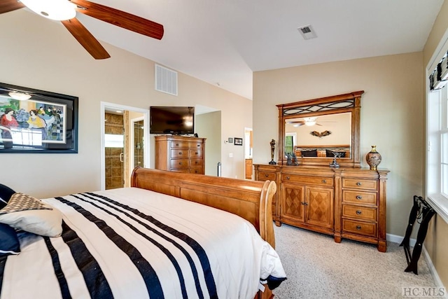 bedroom featuring light carpet, vaulted ceiling, connected bathroom, and ceiling fan