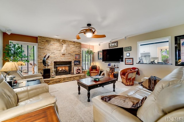 carpeted living room with a fireplace and ceiling fan