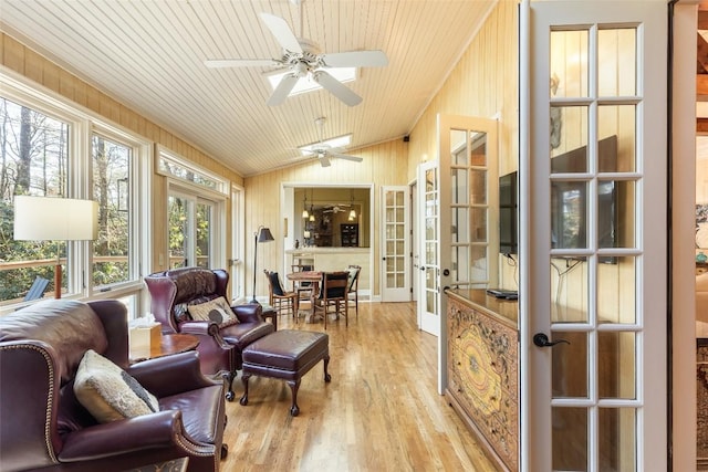 interior space featuring vaulted ceiling, wood walls, wooden ceiling, light wood-type flooring, and french doors