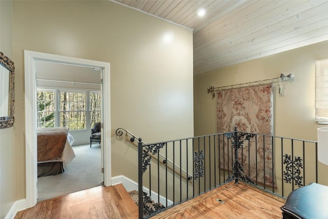 staircase featuring hardwood / wood-style floors, vaulted ceiling, and wooden ceiling