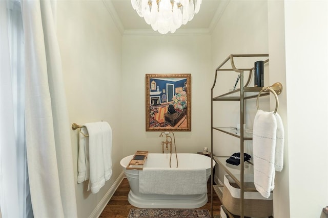 bathroom with hardwood / wood-style flooring, ornamental molding, a washtub, and a chandelier