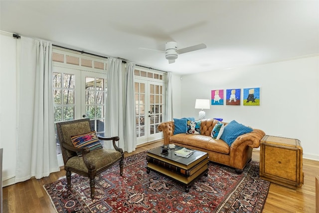 living room with wood-type flooring, ceiling fan, and french doors