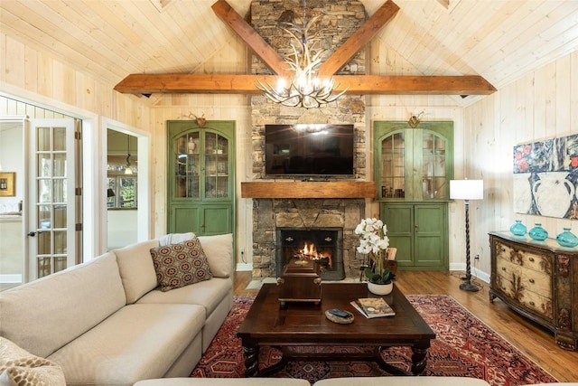 living room with lofted ceiling with beams, a stone fireplace, hardwood / wood-style floors, and wooden walls