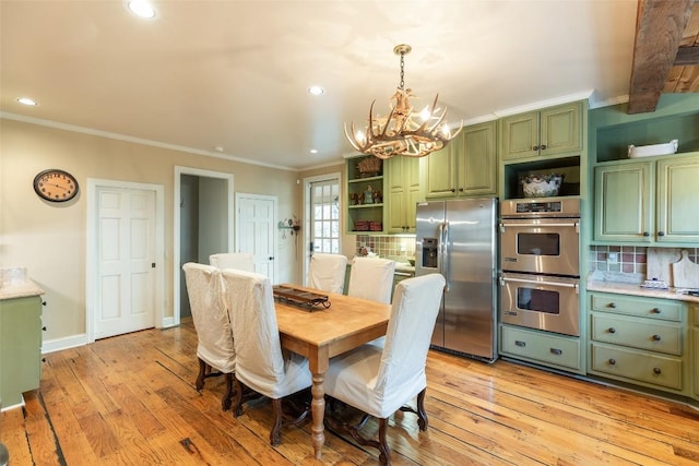 dining area with crown molding, light hardwood / wood-style flooring, and a chandelier