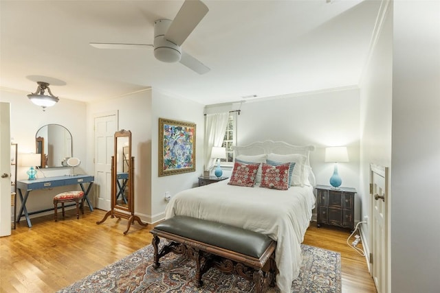 bedroom with ceiling fan, ornamental molding, and light hardwood / wood-style flooring